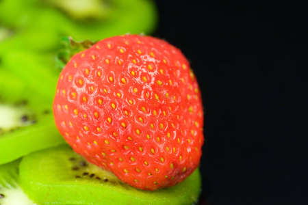 Kiwi slices with fresh red strawberry on topの写真素材