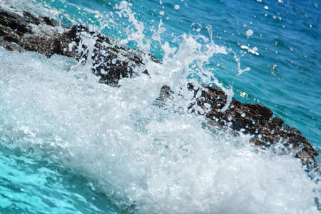 Splashing wave on a rocky beachの写真素材