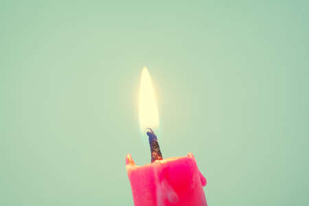 Close up of a burning red candle , retro style toned photo with shallow DOFの写真素材