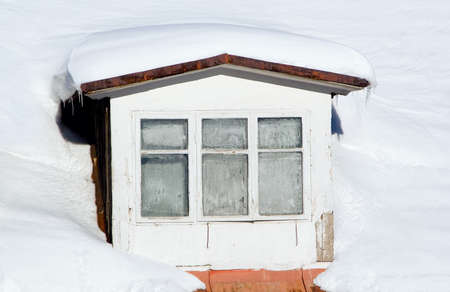 Old window on abandoned mountain house in winter timeの写真素材