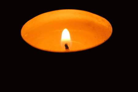One wax candle burning in the darkの写真素材