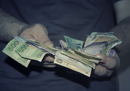 Drug dealer holding money (indonesian currency) in his hands , retro style toned photoの写真素材