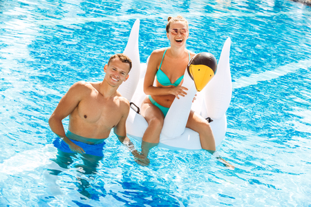 Young couple active leisure swimming pool concept
