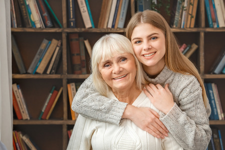 Granddaughter taking care of her retired grandmother huggingの写真素材