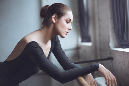 Young ballet dancer leaning on crossbar in studio active lifestyleの写真素材