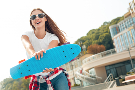 Young woman with skateboard outdoors active lifestyleの写真素材