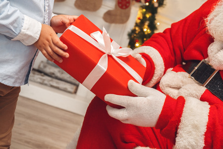 Santa Claus with kids indoors christmas celebration conceptの写真素材