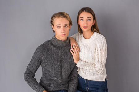 Young couple studio isolated on grey wall conceptの写真素材