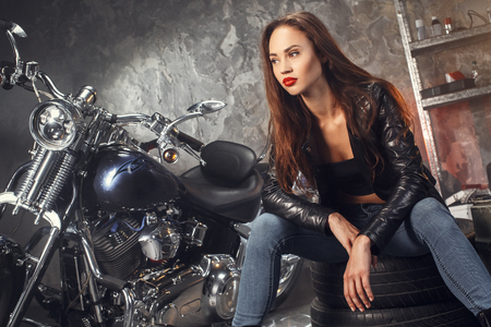 Young woman with motorcycle studioの写真素材