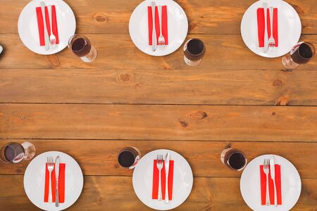 Plates, six glasses with red wine. Festive table set for six people. Wooden background top view mock-up. Wooden background top view mock-upの写真素材