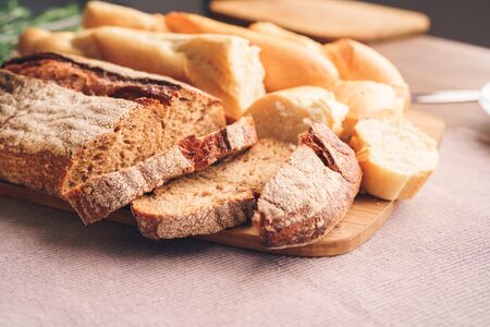 Different types of bread cut into pieces lie on the tableの写真素材