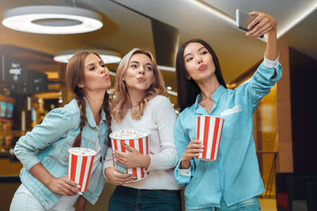 Young people friends together in the cinemaの写真素材