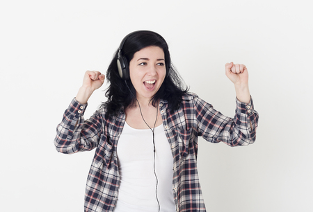 Young happy woman in a big headphones sings his favorite song anの写真素材