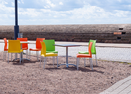 Empty tables and beautiful colourful plastic chairs in a street cafe in Europe.の写真素材