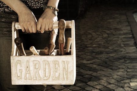 Lady carrying a garden basket with tools
