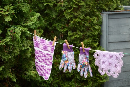 Gloves and cloths hanging outside to dryの写真素材