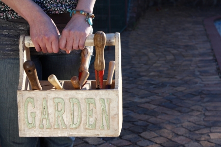 Lady carrying a garden basket with toolsの写真素材