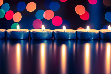 Candles on the background of Christmas lightsの写真素材