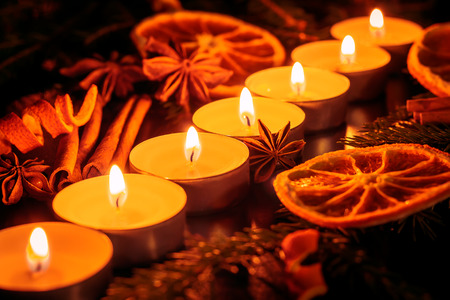 Composition with candles, oranges, star anise, cinnamon and Christmas tree branchesの写真素材