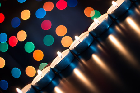 Candles on the background of Christmas lightsの写真素材