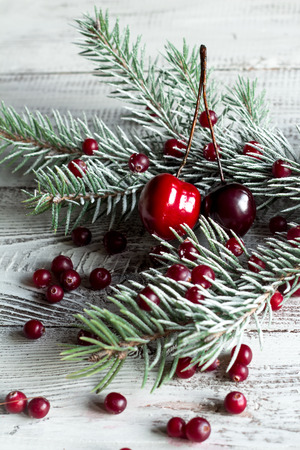 Cranberries, cherries and Christmas tree branches on a wooden tableの写真素材