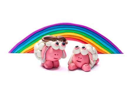 Rainbow and two plasticine sheep.  White background.の写真素材