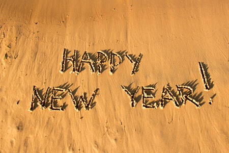 The inscription "Happy new year" on the sand. Sunset on the beach.の写真素材