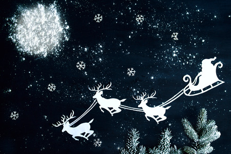 Santa Claus and reindeer flying through the night sky. Christmas background.の写真素材