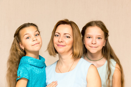 Mother and her two daughters looking at camera. Family portrait.の写真素材