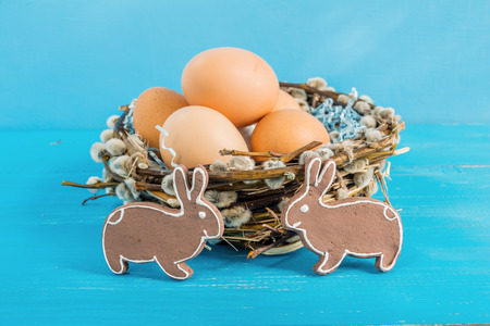 Festive composition of Easter eggs, rabbit and willow branches.