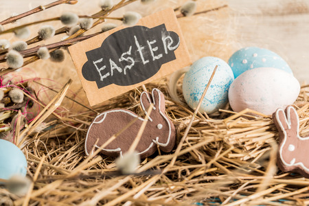 Festive composition of Easter eggs, rabbit and willow branches.の写真素材