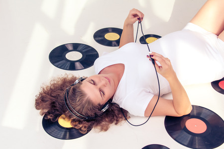 Beautiful woman in a big headphones listening to music and relaxing.の写真素材