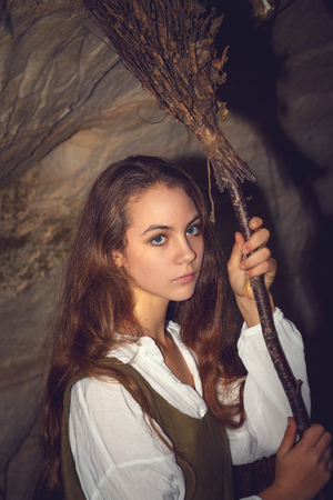 Young beautiful witch in her cave. Fairy tale about Halloween.の写真素材