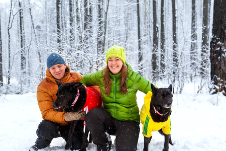 Active loving family walk the dog in the winter forest. Family fun.の写真素材