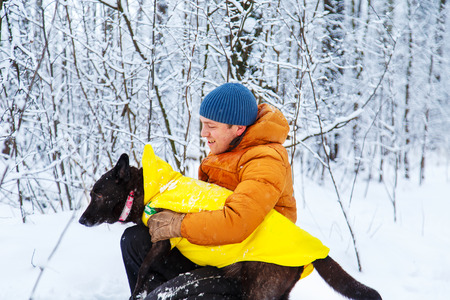 Active man walking the dog in the winter forest.の写真素材