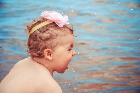 Cute little girl playing in the sea. Beach vacation.の写真素材