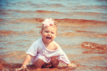 Cute little girl playing in the sea. Beach vacation.の写真素材
