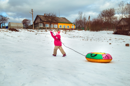 Little funny girl walking outdoors in winter. Active holidays.
