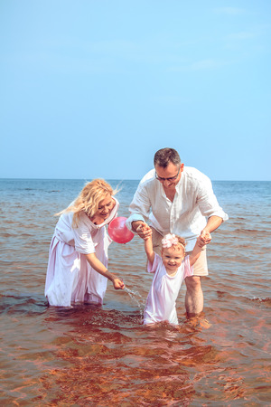 Happy family with baby playing on the beach. Family fun.の写真素材