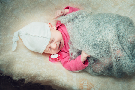 Newborn baby lies in a crib under the duvet blanked.の写真素材
