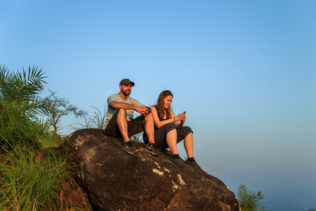 Group of tourists watching the sunset on top of the mountain. Rest after climbing.の写真素材