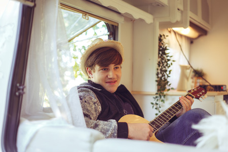 Young traveler with a guitar in his camper van.の写真素材