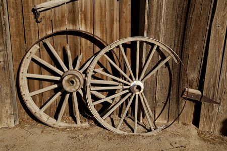 Two broken, wooden cart wheels