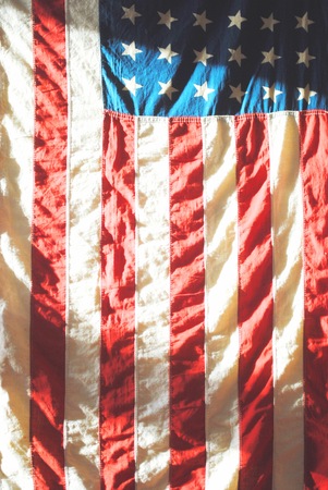 American Flag hanging on a wall in dramatic lightの写真素材