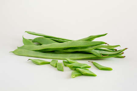 A group of fresh green flat runner beans whole and sliced on white background isolated with copy...