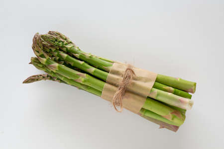 A bundle of beautiful raw green asparagus on a white background, copy space, horizontalの写真素材