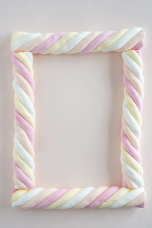 Top down view of marshmallow sweets (in Dutch: kabelpekjes) in the form of a picture frame on soft...