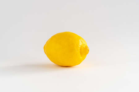 Close-up of a single whole lemon on a white background with copy space, horizontalの写真素材