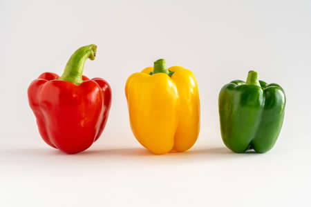 Close-up of three bell peppers in a row on a white background, with copy space, horizontalの写真素材