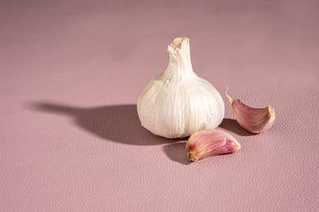 Purple garlic bulb and cloves on pink background, horizontalの写真素材